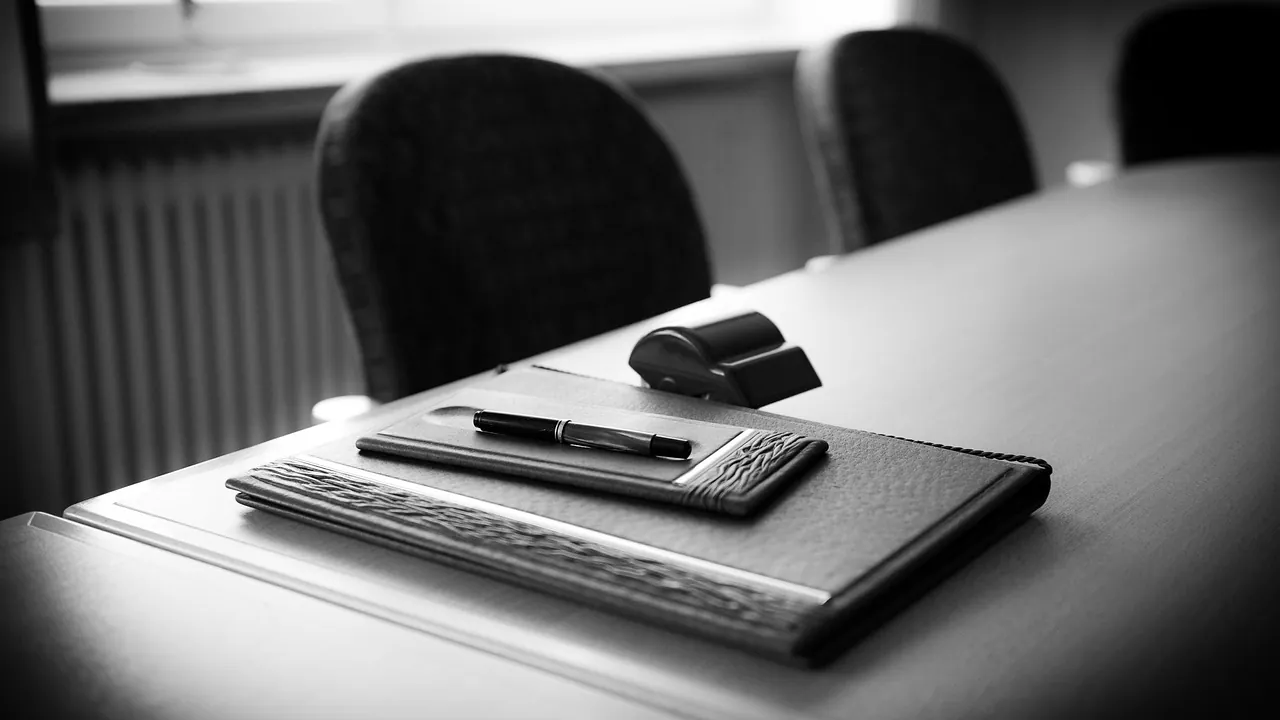 Table de réunion avec carnet et stylo, en noir et blanc