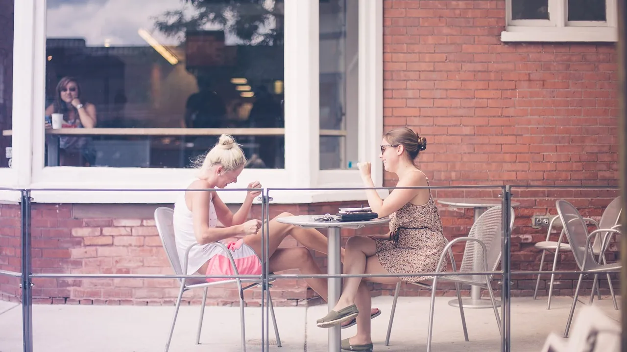 Deux femmes en conversation à une terrasse de café